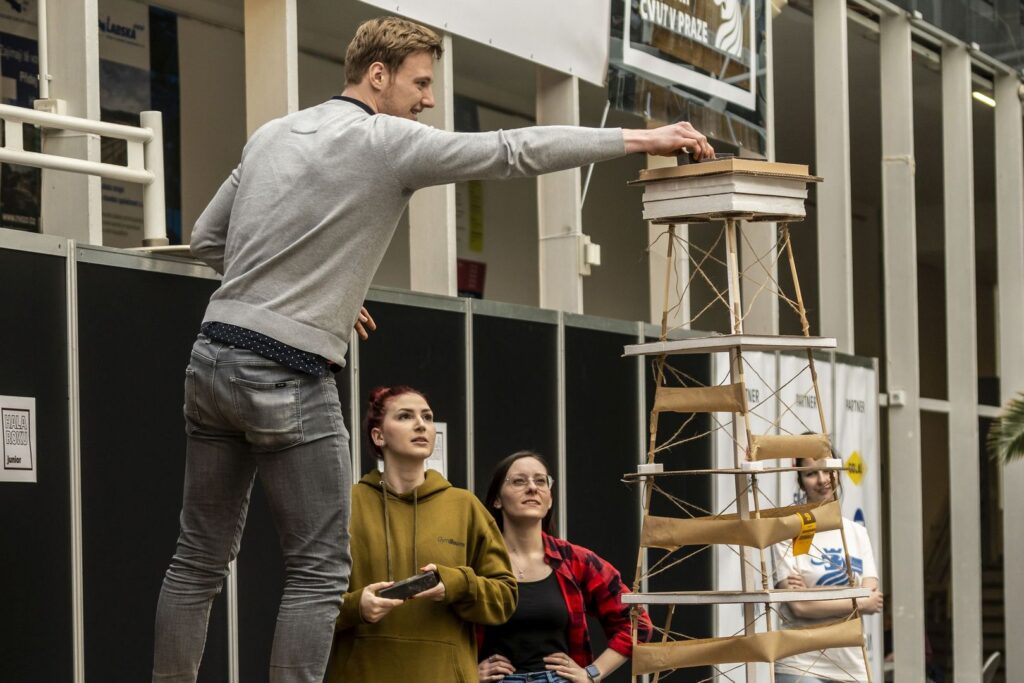 jeden ze soutěžních týmů zatěžuje jejich model při zátěžové zkoužce